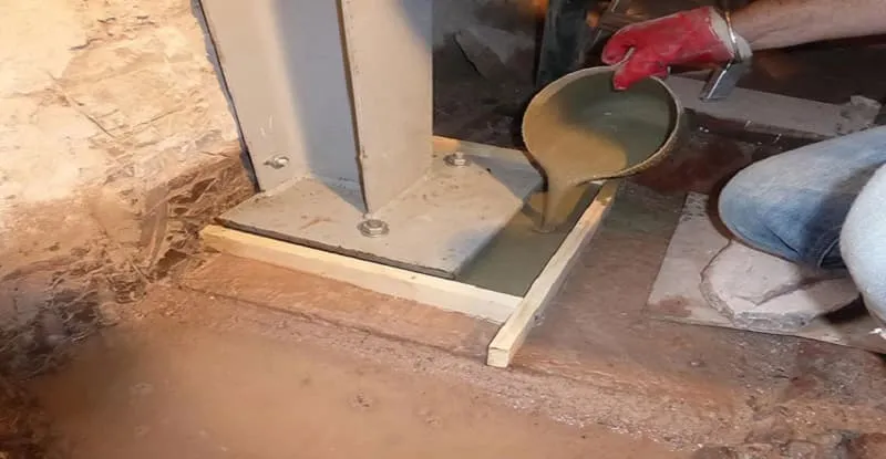 a man is pouring grout into concrete