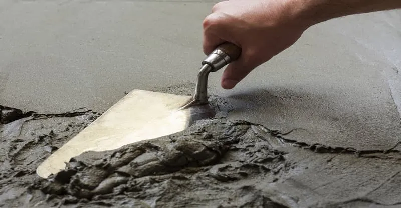 a man is repairing concrete with grout