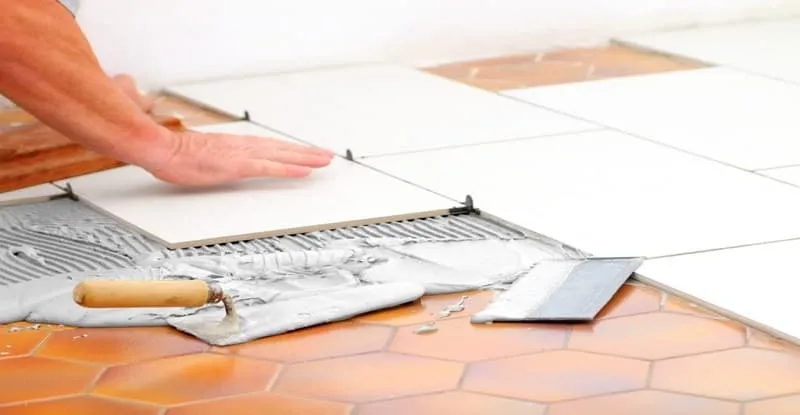 a man is gluing tile on tile