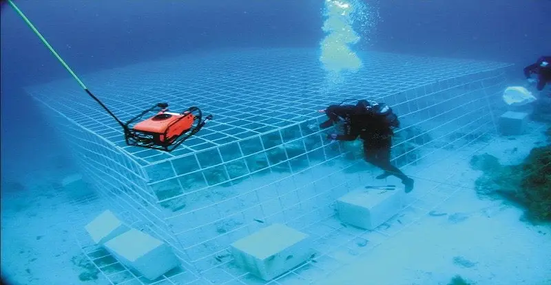 A man pouring concrete under water